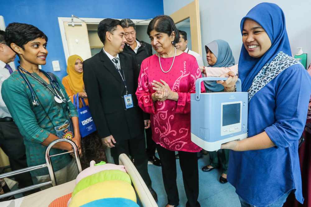 Datuk Ambiga Sreenevasan (centre) presents the life support ventilator to Adam Miqailu00e2u20acu2122s parents Azlina Ilias and Shahrul Hisham, together with Malay Mail Care Fund trustees, May 24, 2019. u00e2u20acu2022 Picture by Hari Anggara