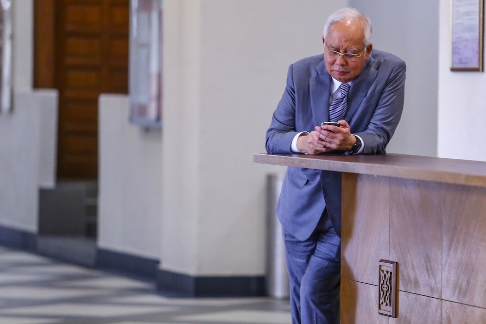 Datuk Seri Najib Razak checks his phone at the Kuala Lumpur Court Complex May 29, 2019. — Picture by Hari Anggara