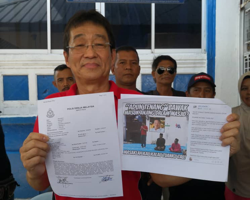 Labis MP Pang Hok Liong holding a copy of his police report and also a copy of the insulting Facebook posting after lodging a report at the Segamat police station today. u00e2u20acu201d Picture courtesy of Pang Hok Liong