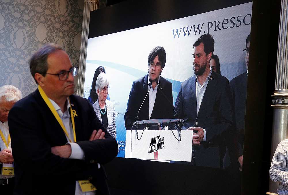 Catalan Regional President Quim Torra watches former Catalan Regional President and 'Junts x Catalunya' candidate Carles Puigdemont speaks from Belgium via video wall in Barcelona May 27, 2019. u00e2u20acu201d Reuters pic