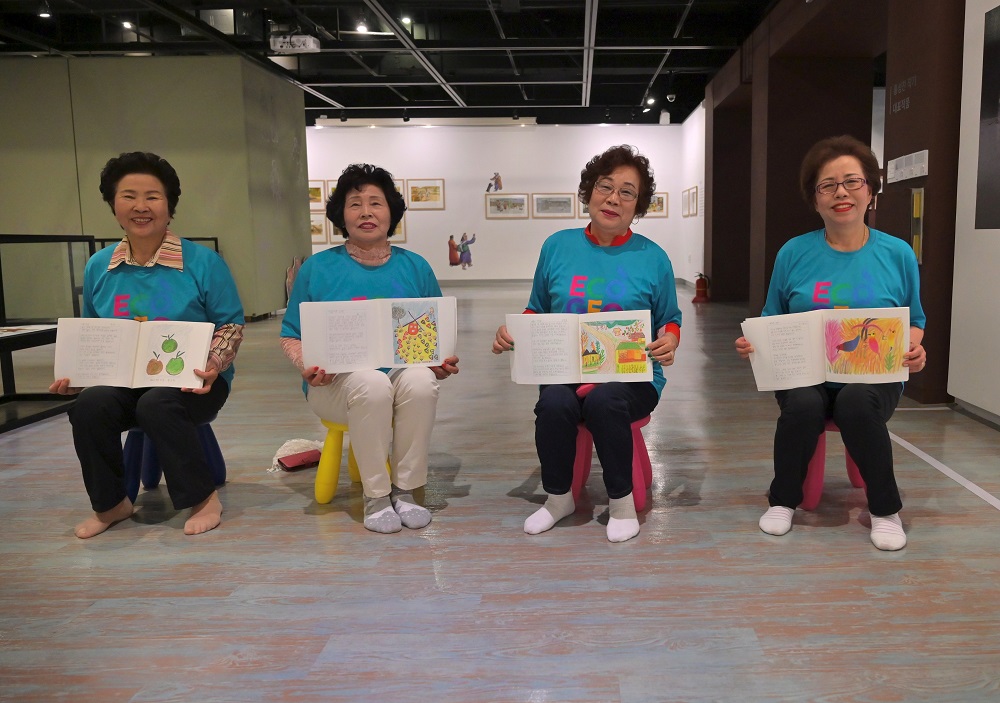 This picture taken on May 14, 2019 shows elderly South Korean women posing with books containing their own writing and paintings at a city-run library in Suncheon, 320km south of Seoul. u00e2u20acu2022 AFP pic         