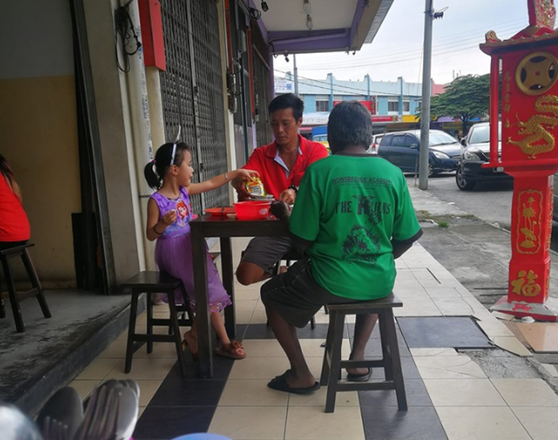 A father and daughter are pictured having a meal of bak kut teh with a man who appeared to be homeless. u00e2u20acu201d Picture from Facebook/ Willy Chong
