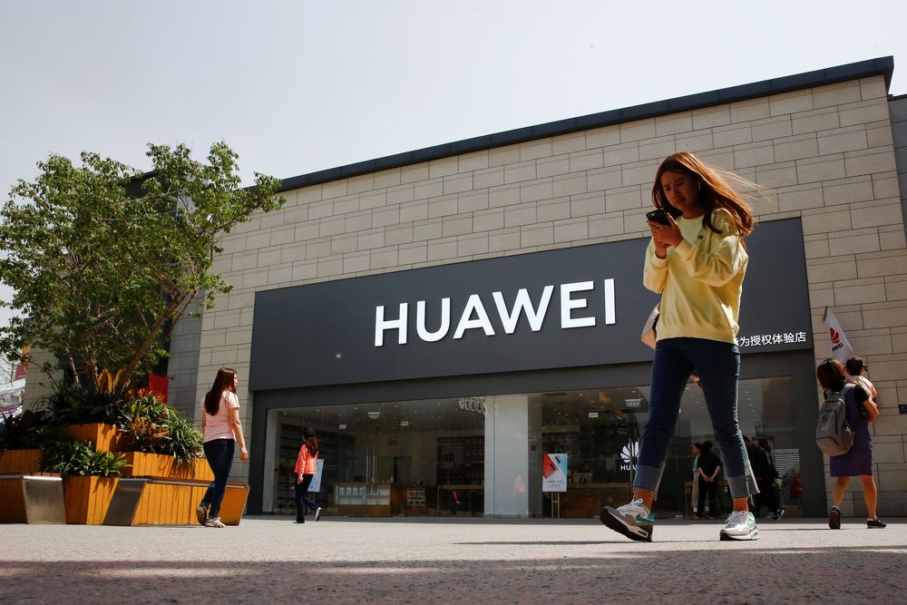 A woman looks at her phone as she walks past a Huawei shop in Beijing, China May 16, 2019. u00e2u20acu201d Reuters pic