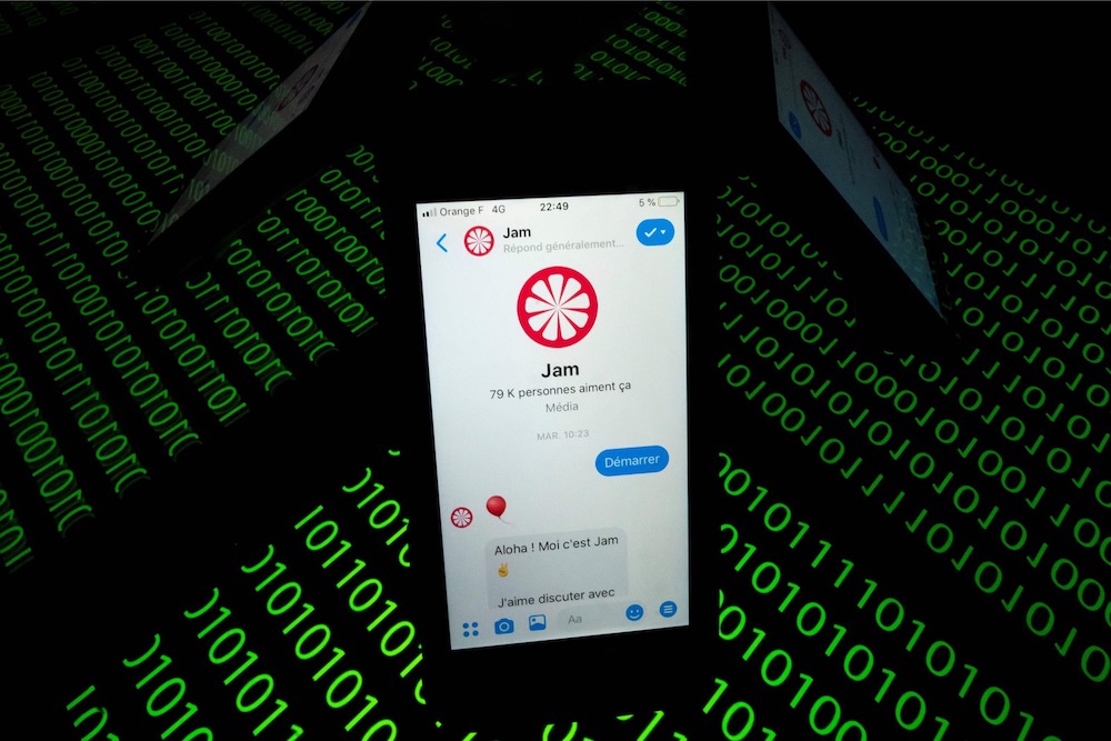This file photo taken on February 28, 2019 shows the u00e2u20acu02dcJamu00e2u20acu2122 chat bot displayed on a smartphone and a binary code displayed by a tablet in Paris. u00e2u20acu201d AFP pic