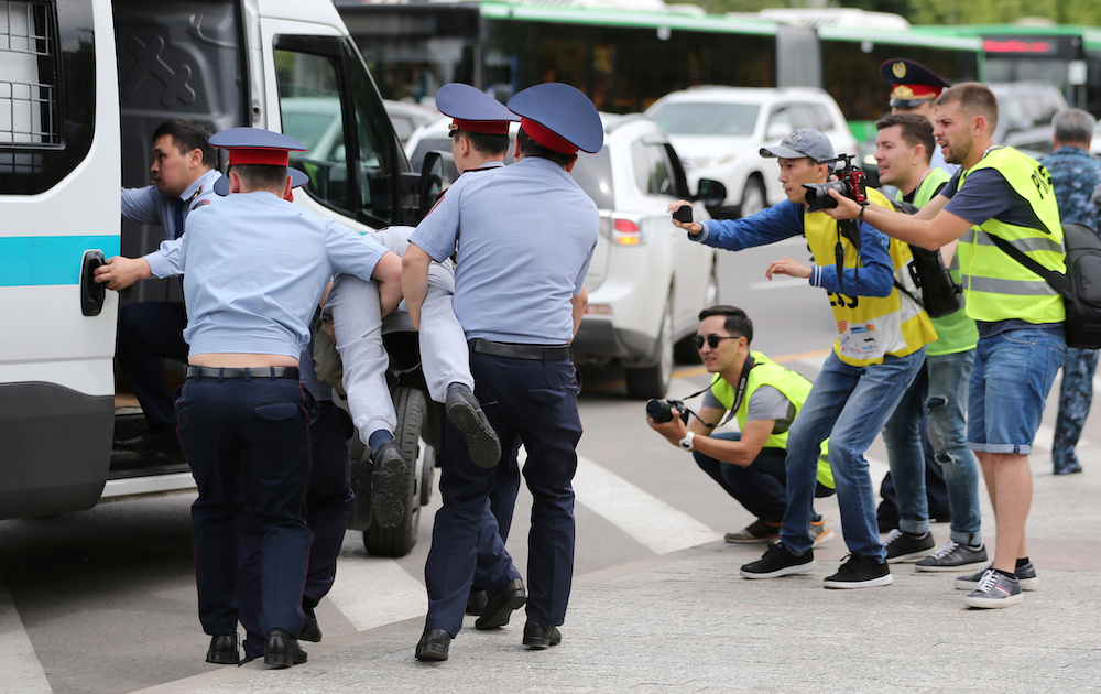 Police officers detain an opposition supporter as journalists take pictures during a protest against presidential election results, in Almaty, Kazakhstan, June 10, 2019. u00e2u20acu201d Reuters pic