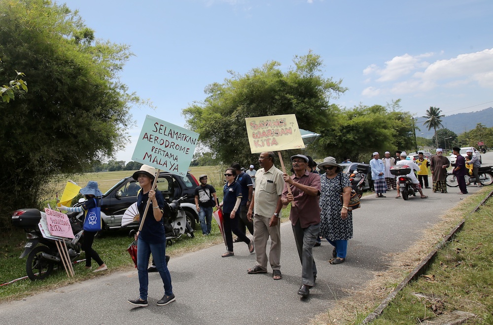 People hold banners during a demonstration against the rumoured sale of Aerodome Taiping in Taiping June 14, 2019. — Picture by Farhan Najib