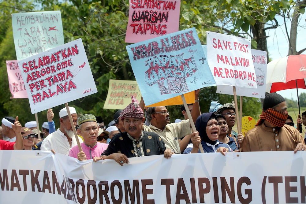 People hold banners during a demonstration against the rumoured sale of Aerodome Taiping in Taiping June 14, 2019. u00e2u20acu201d Picture by Farhan Najib
