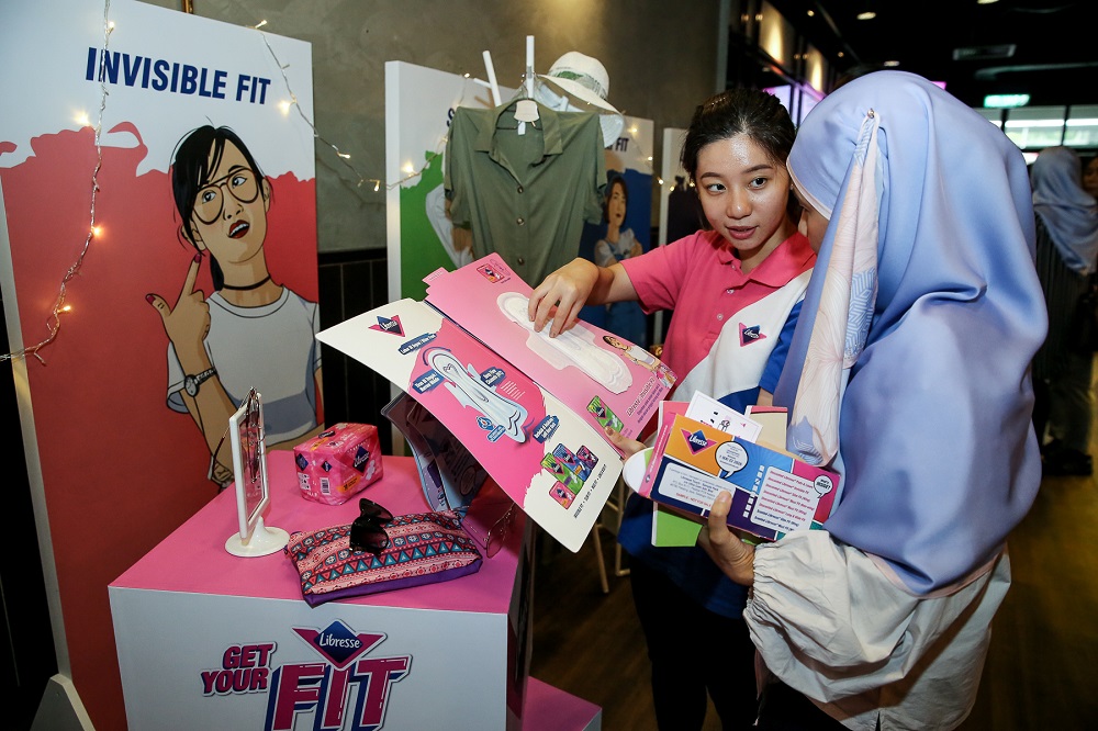 A Libresse promoter explaining the traits of the Invisible Fit pads to a guest. — Picture by Yusof Mat Isa