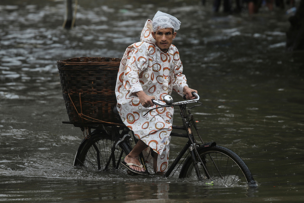 A man rides a bike through a water-logged street during heavy rains in Mumbai July 1, 2019. u00e2u20acu201d Reuters pic