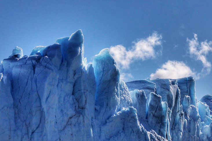 Wisps of clouds behind the icy peaks