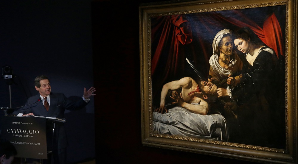 French art expert Eric Turquin speaks alongside a painting, believed to be the second version of u00e2u20acu02dcJudith Beheading Holofernesu00e2u20acu2122 by Italian artist Caravaggio, during a photocall in London on February 28, 2019, following its restoration. u00e2u20acu2022 AFP pic     