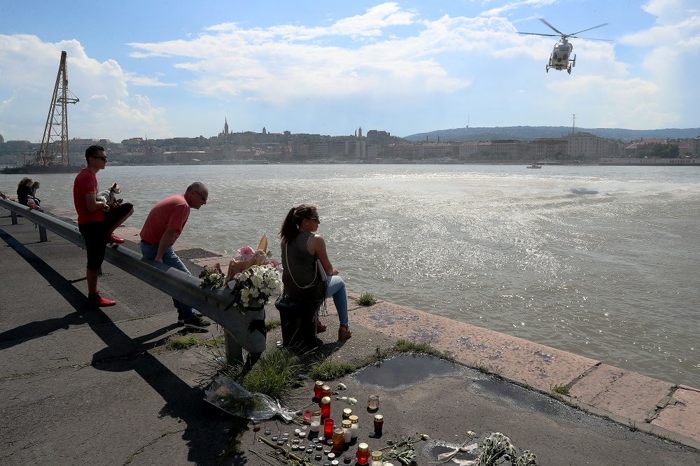 A search and rescue helicopter flies over the Marit bridge in Budapest on June 2, 2019, as onlookers watch the operations where a vessel collided with a smaller Mermaid, carrying mainly S. Korean tourists, causing it to sink. u00e2u20acu201d AFP pic