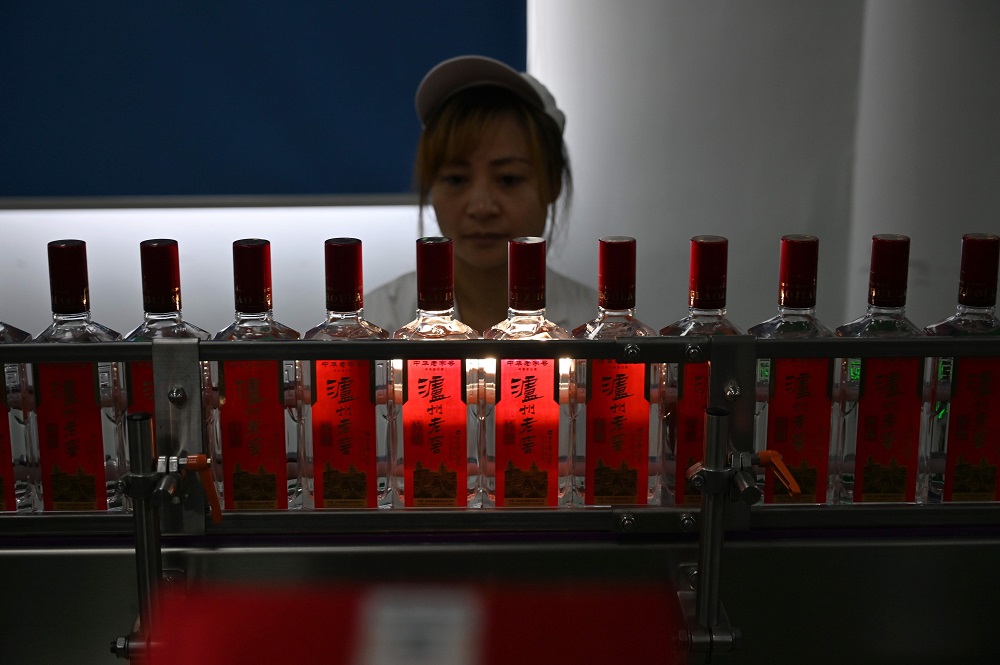In this photo taken on April 23, 2019, an employee inspects baijiu liquor on a production line at the Luzhou Loajian bottling plant in Luzhou, southwestern Chinau00e2u20acu2122s Sichuan province. u00e2u20acu201d AFP pic        