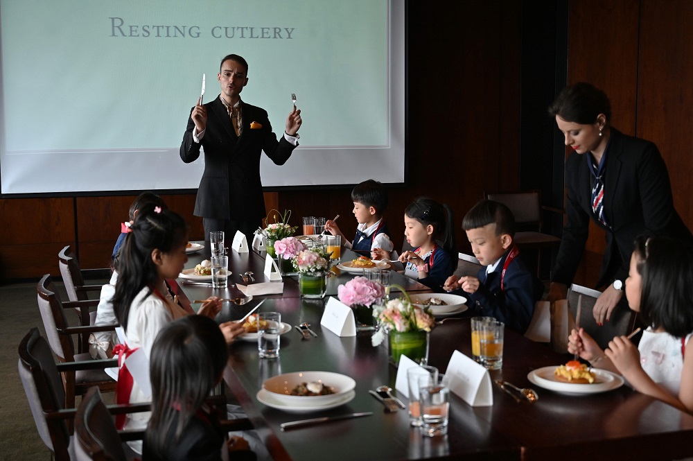 This picture taken on June 1, 2019, shows Guillaume de Bernadac teaching children how to use cutlery during an etiquette and manners class in central Shanghai. ― AFP pic