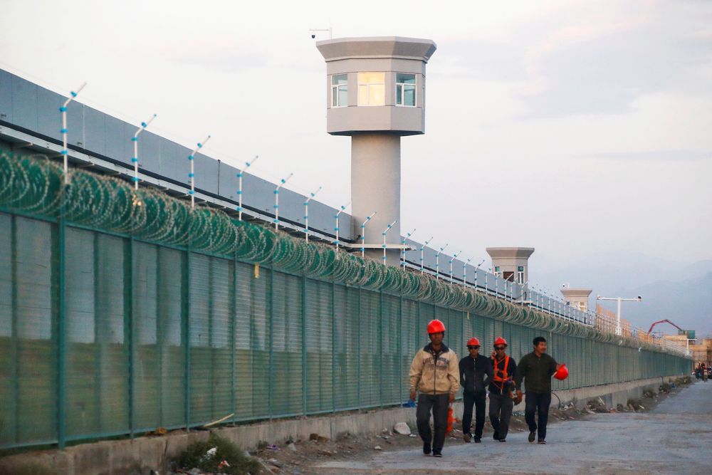 Workers walk by the perimeter fence of what is officially known as a vocational skills education centre in Dabancheng in Xinjiang Uighur Autonomous Region, China September 4, 2018. u00e2u20acu201d Reuters pic