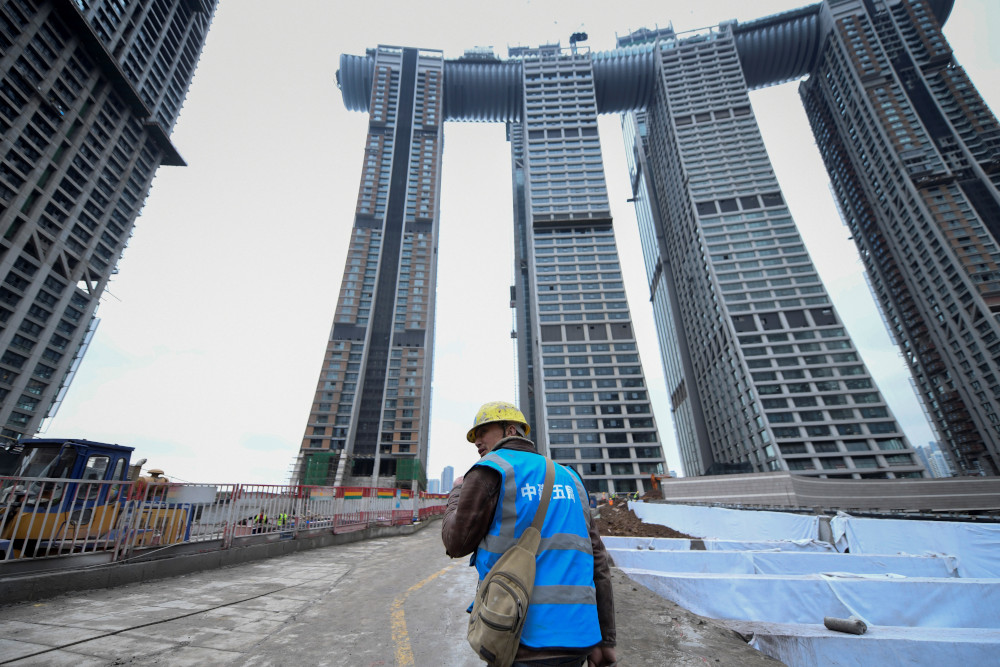 This picture taken March 22, 2019 shows a worker walking at the construction site of the Raffles City Chongqing in southwest Chinau00e2u20acu2122s Chongqing Municipality. u00e2u20acu201d AFP 