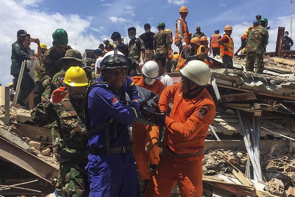 Rescue workers remove a victim from the debris after an under-construction building collapsed in Sihanoukville on June 22, 2019. u00e2u20acu201d AFP pic