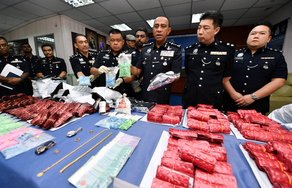 Johor police chief Datuk Mohd Khalil Kader Mohd holds some of the seized drugs during a press conference in Johor Baru June 2, 2019. u00e2u20acu201d Bernama pic