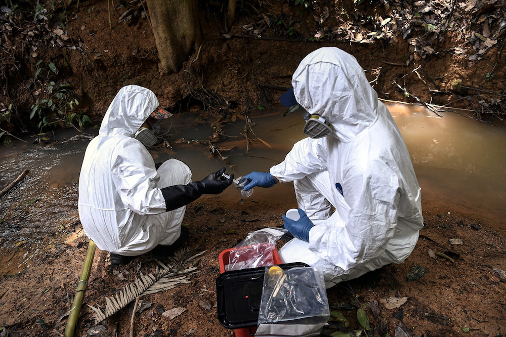 Hazmat personnel from the Kelantan Fire and Rescue Department take water samples at the Kuala Koh Orang Asli settlement in Gua Musang June 11, 2019. u00e2u20acu201d Bernama pic