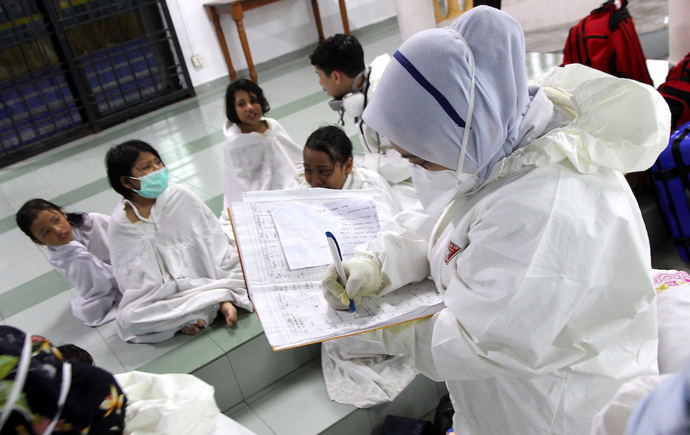 An emergency services staff records details of students with reported breathing difficulties at Sekolah Agama Taman Mawar in Pasir Gudang June 20, 2019. u00e2u20acu201d Bernama pic