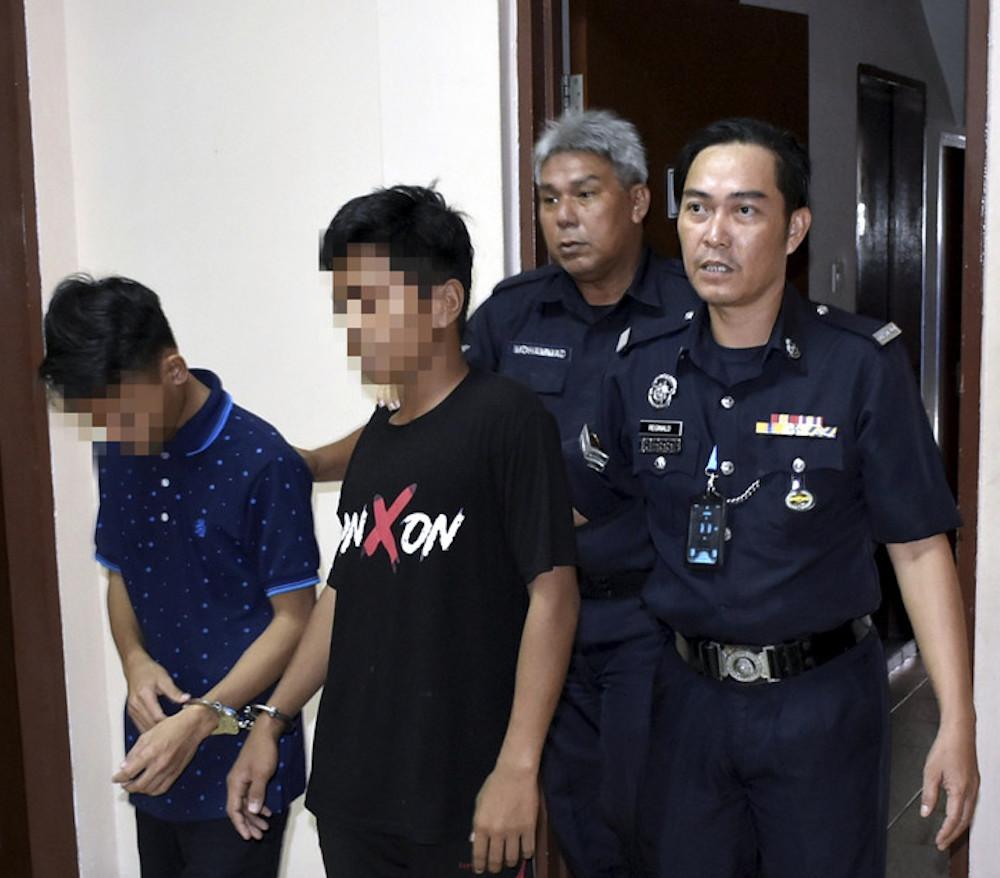 Two of the accused are escorted by policemen, as they leave the Tawau Magistrateu00e2u20acu2122s Court June 25, 2019. u00e2u20acu201d Bernama pic