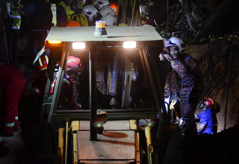 Fire and Rescue Department personnel search for victims of a landslide in Tanjung Bungah, George Town June 25, 2019. u00e2u20acu201d Bernama pic