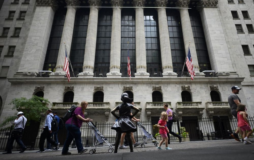 Tourists pass the Fearless Girl statue in front of the New York Stock Exchange (NYSE) on June 18, 2019 in New York City. u00e2u20acu201d AFP pic