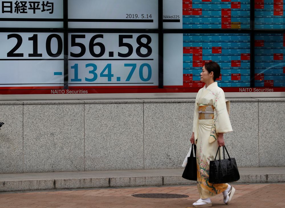 A woman wearing a kimono walks past an electronic board showing the Nikkei stock index outside a brokerage in Tokyo, Japan, May 14, 2019. u00e2u20acu201d Reuters pic