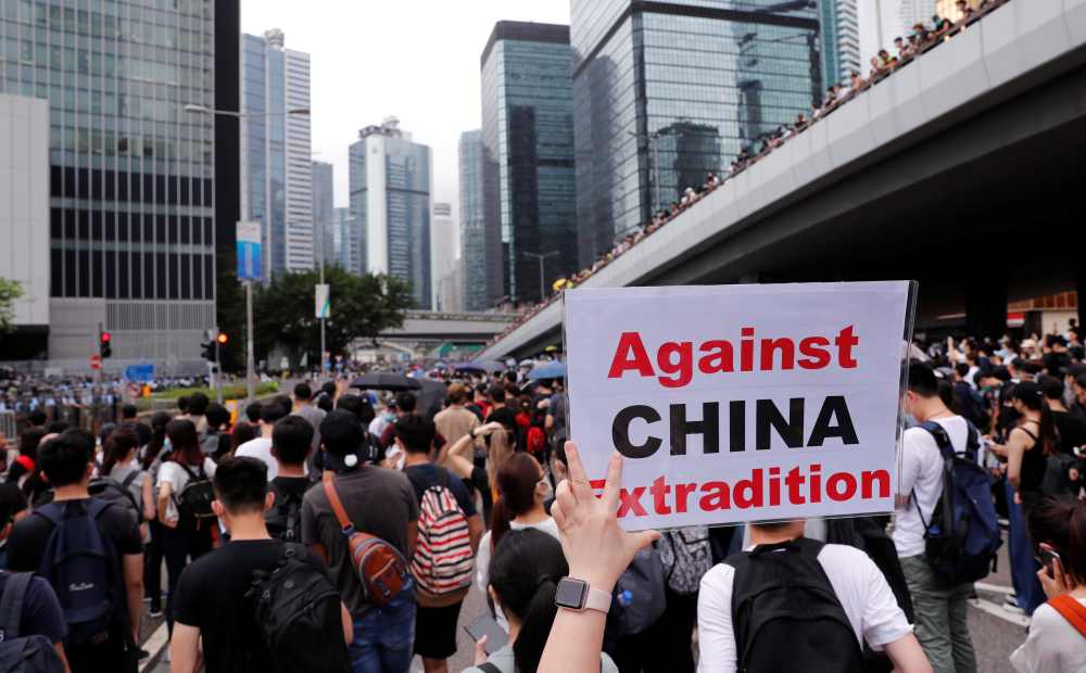 A protester holds a placard reading u00e2u20acu02dcAgainst China extraditionu00e2u20acu2122 during a demonstration against a proposed extradition bill in Hong Kong June 12, 2019. u00e2u20acu2022 Reuters pic