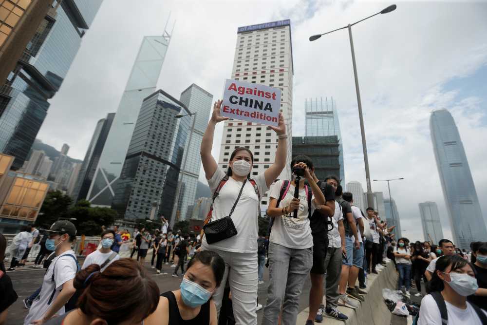 A protester holds up a placard reading u00e2u20acu02dcAgainst China extraditionu00e2u20acu2122 during a demonstration against a proposed extradition bill in Hong Kong June 12, 2019. u00e2u20acu2022 Reuters pic
