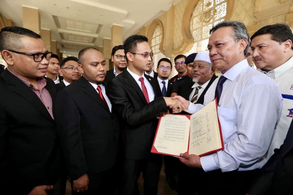 Johor Opposition leader Datuk Hasni Mohammad (right) hands over the memorandum to the Johor MBu00e2u20acu2122s private secretary Muhd Shamsuddin Paijan at the state administrative office in Iskandar Puteri. u00e2u20acu201d Picture by Ben Tan