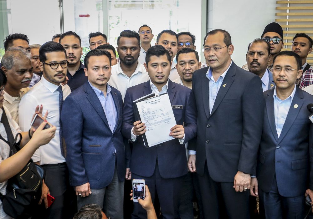 Datuk Seri Azmin Aliu00e2u20acu2122s political secretary Muhammad Hilman Idham holds up a copy of the police report at the Federal Territories Islamic Religious Department in Putrajaya June 13,2019. u00e2u20acu201d Picture by Firdaus Latif