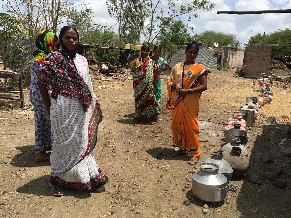 Women stand next to a row of pots placed for the water tanker that comes every two days at Salegaon village in Beed, India June 18, 2019. u00e2u20acu201d Thomson Reuters Foundation pic