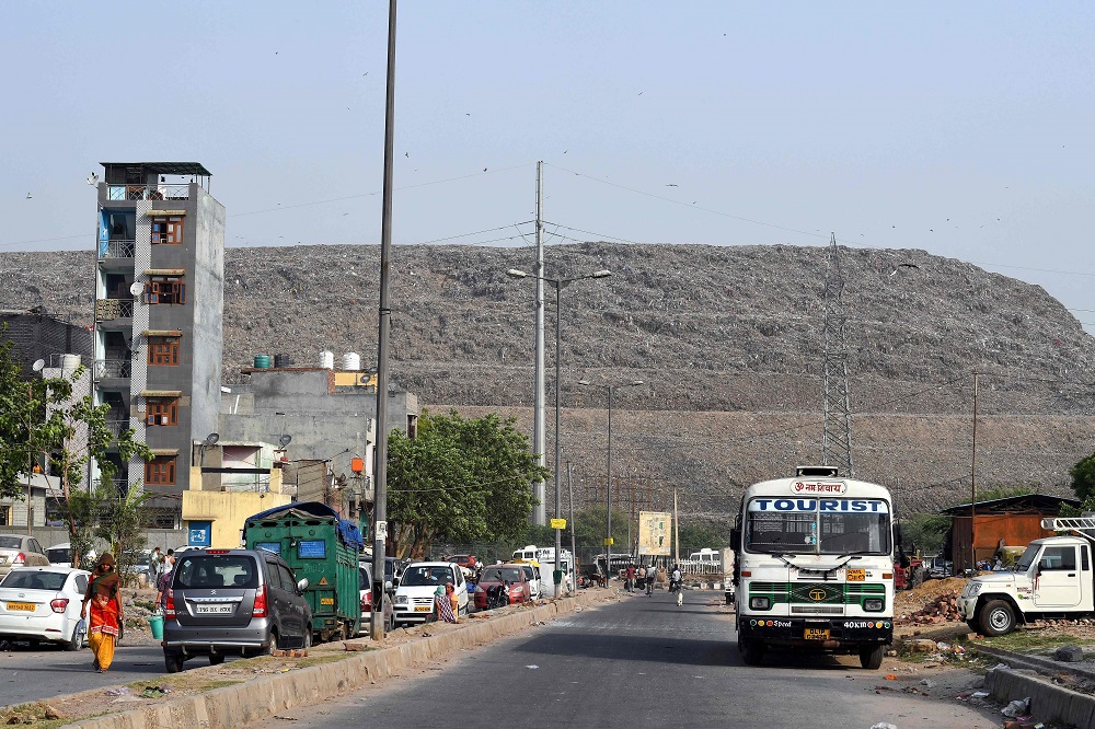 In this picture taken on June 3, 2019, Indian residents walk along a road near the Ghazipur landfill site in the east of New Delhi. u00e2u20acu201d AFP pic         