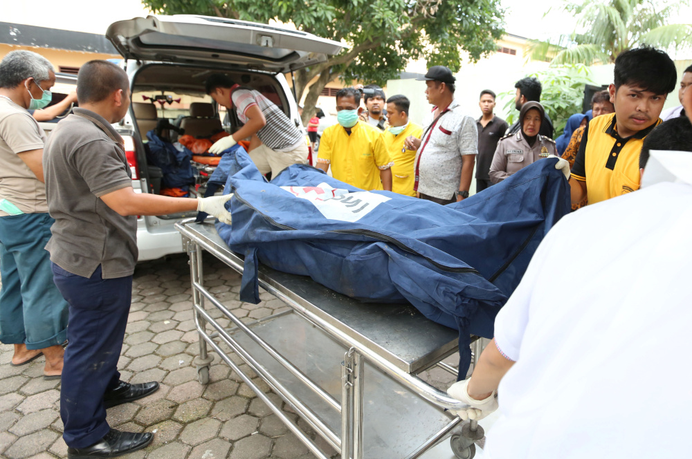 An officer helps transport a body bag containing a victim who died in a fire at a matchsticks factory, at Bhayangkara hospital in Medan, North Sumatra province, June 21, 2019. u00e2u20acu201d Antara Foto/Septianda Perdana handout pic via Reuters 