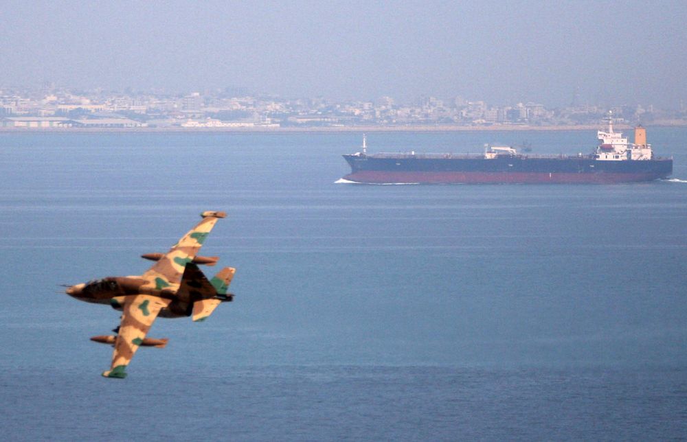 An Iranian military fighter plane flies past an oil tanker during naval manoeuvres in the Gulf and Sea of Oman April 5, 2006. u00e2u20acu201d Fars News/File Photo via Reuters