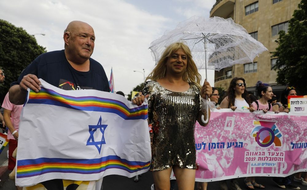 Participants to the 18th annual Jerusalem Gay Pride parade carry a rainbow-adorned national flag as they march in the Holy City on June 6, 2019. u00e2u20acu201d AFP pic