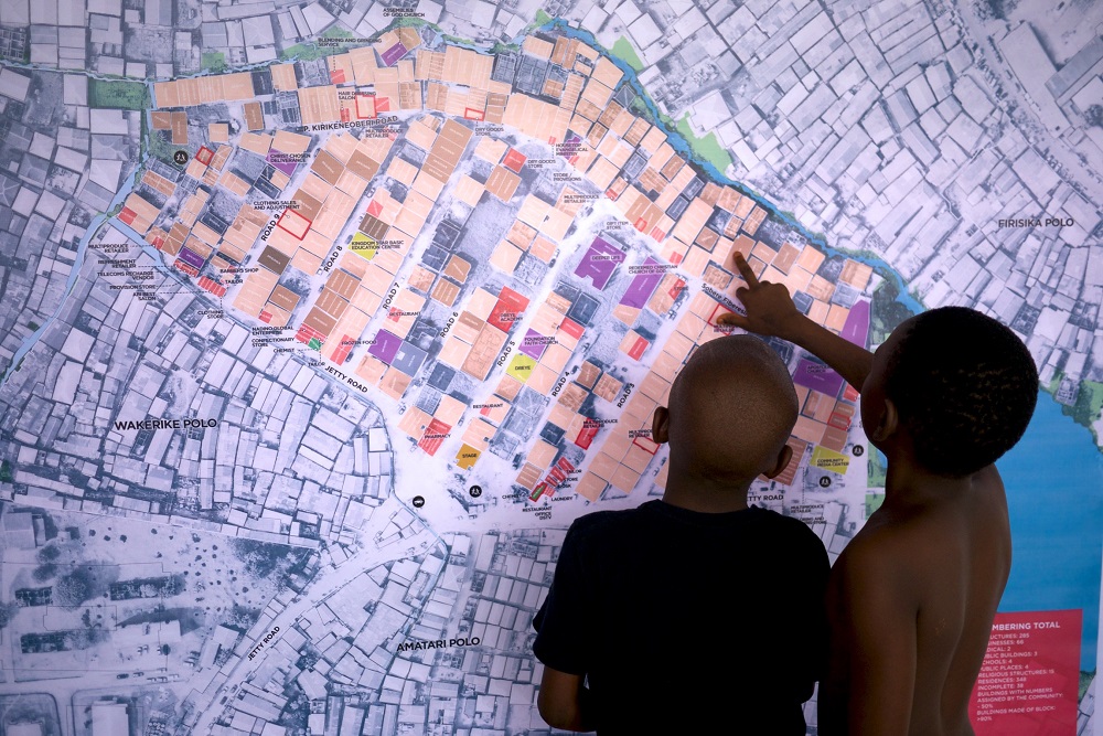 Emmanuel and Favour point out a friend's house on a Chicoco Maps banner they helped make as part of the Human City Project's community mapping and planning collaboration. u00e2u20acu201d Michael Uwemedimo/CMAP/Thomson Reuters Foundation pic