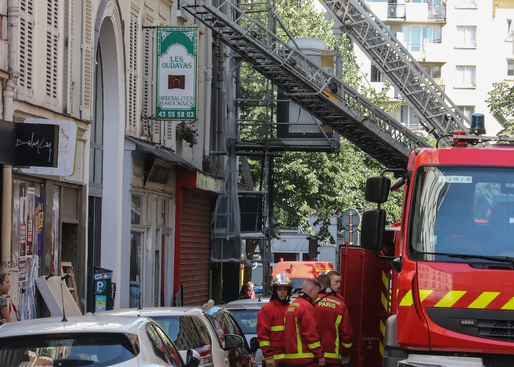 This picture taken on June 22, 2019 shows firefighters standing in front of a building rue de Nemours in Paris, where three people died and another was seriously injured in a fire that broke out early in the morning. u00e2u20acu201d AFP pic