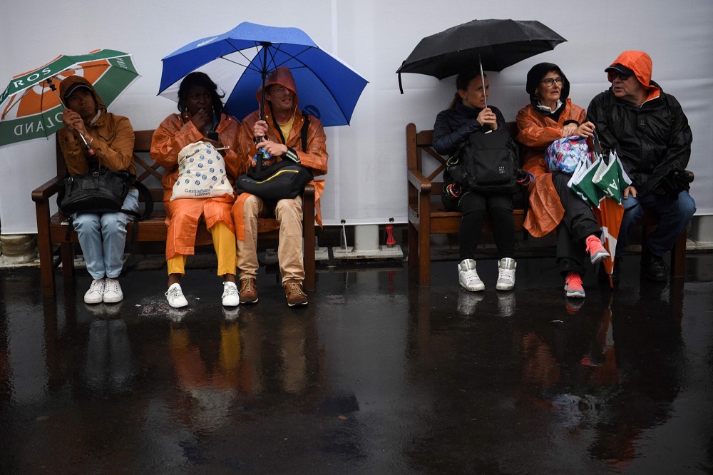 People hold their umbrella as rain falls on day eleven of The Roland Garros 2019 French Open tennis tournament in Paris June 5, 2019. u00e2u20acu201d AFP pic