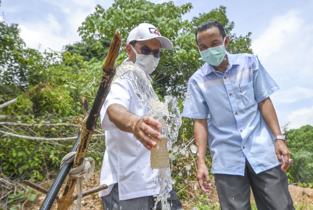 Deputy Minister of Water, Land Natural Resources Tengku Zulpuri Shah Raja Puji (left) collects water samples at Kampung Kuala Koh, Gua Musang June 9, 2019. u00e2u20acu201d Bernama pic