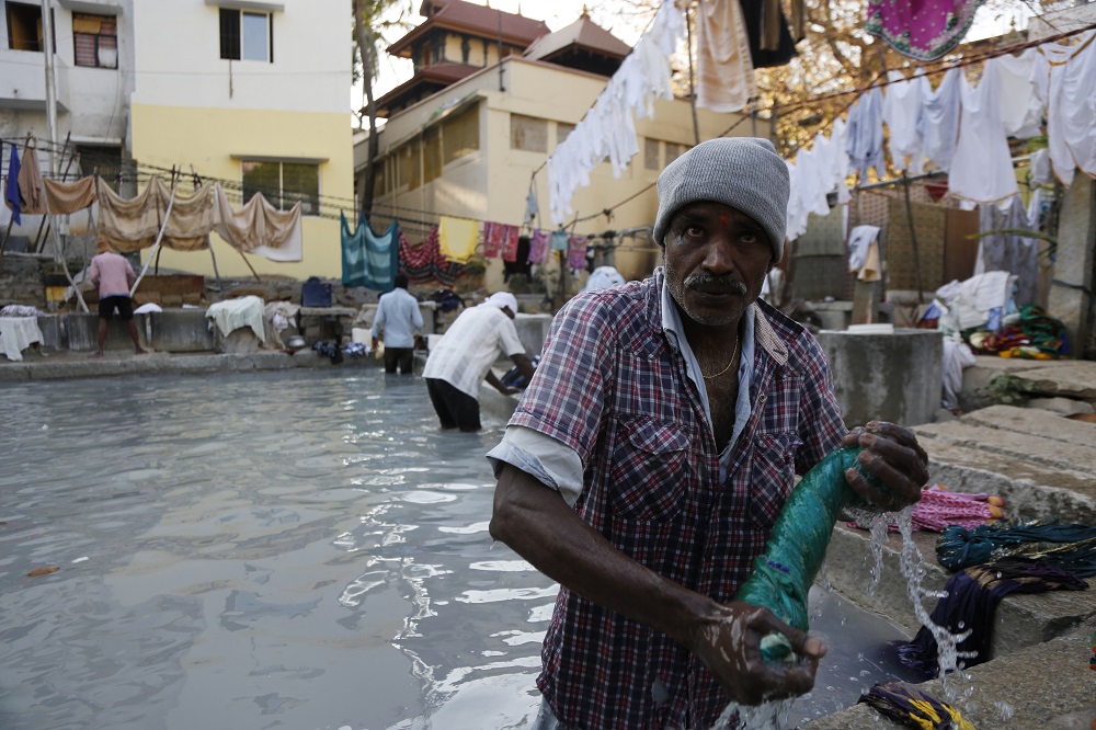 A washerman wrings out clothes at an open-air laundromat in Bangalore, India March 13, 2019. u00e2u20acu201d Thomson Reuters Foundation pic 