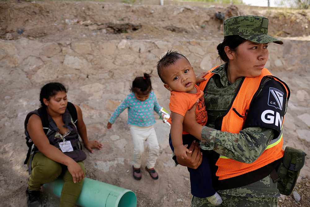 A member of the Mexican National Guard holds a boy of a Honduran migrant after she and her children were stopped from crossing illegally into El Paso, Texas in Ciudad Juarez, Mexico June 26, 2019. u00e2u20acu201d Reuters pic