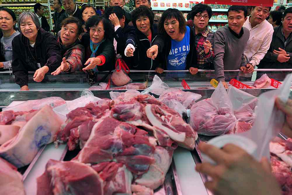 Customers point to chopped pork for sale during a promotional event at a supermarket in Shenyang, Liaoning province, November 9, 2012. u00e2u20acu201d Reuters pic 