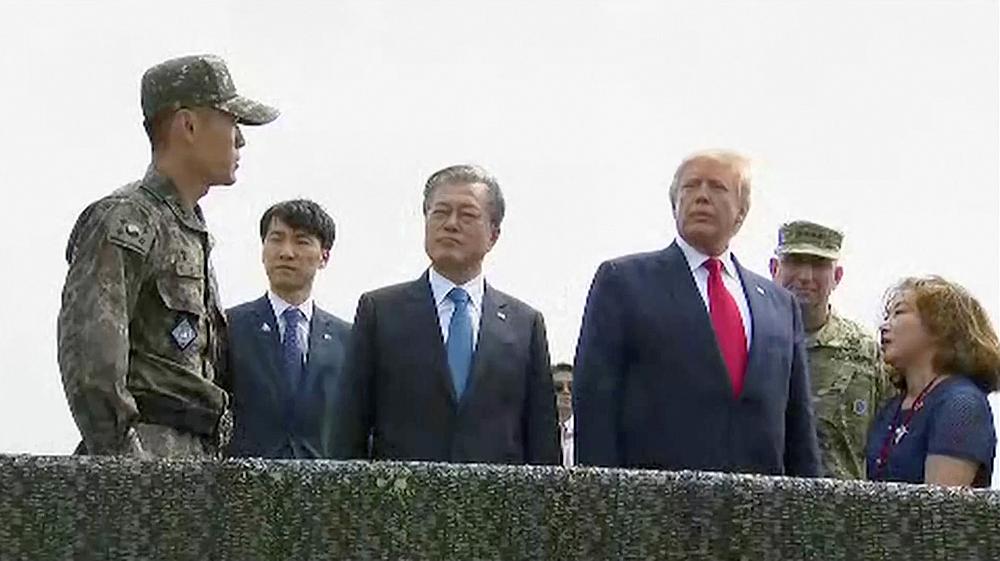 US President Donald Trump (centre right) and South Korean President Moon Jae-in are seen at the demilitarised zone (DMZ) separating the two Koreas, in Panmunjom, South Korea June 30, 2019. u00e2u20acu201d South Korean Pool video image via Reuters
