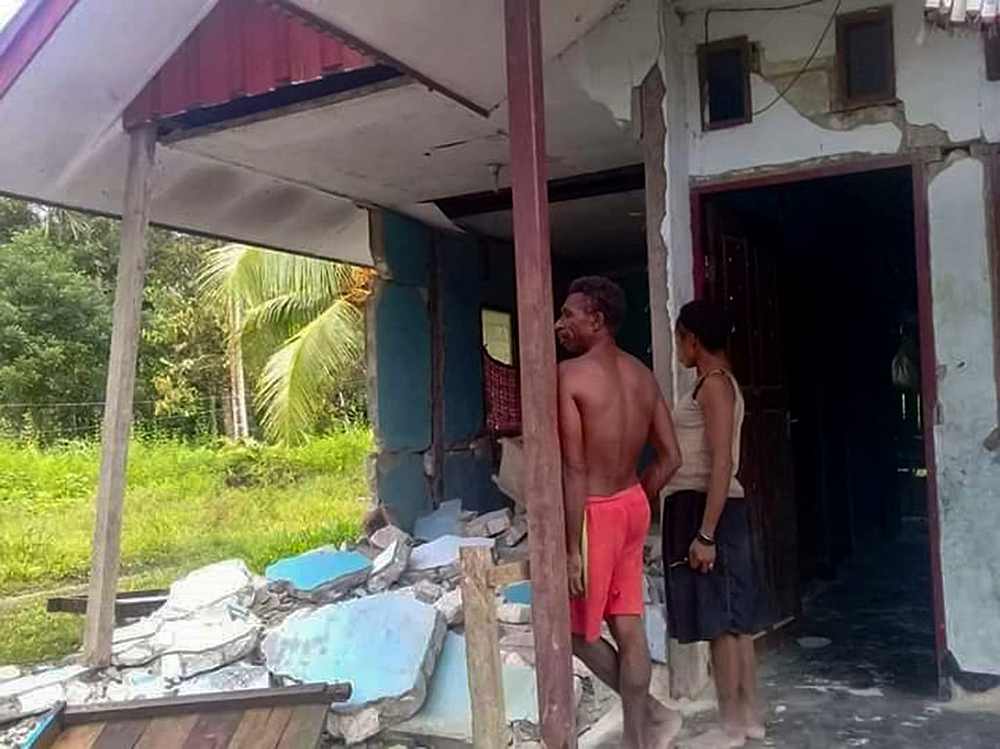 Indonesian villagers standing outside their damaged house after an earthquake struck Sarmi regency, in Indonesia's Papua province June 20, 2019. u00e2u20acu201d BNPB handout via AFP 