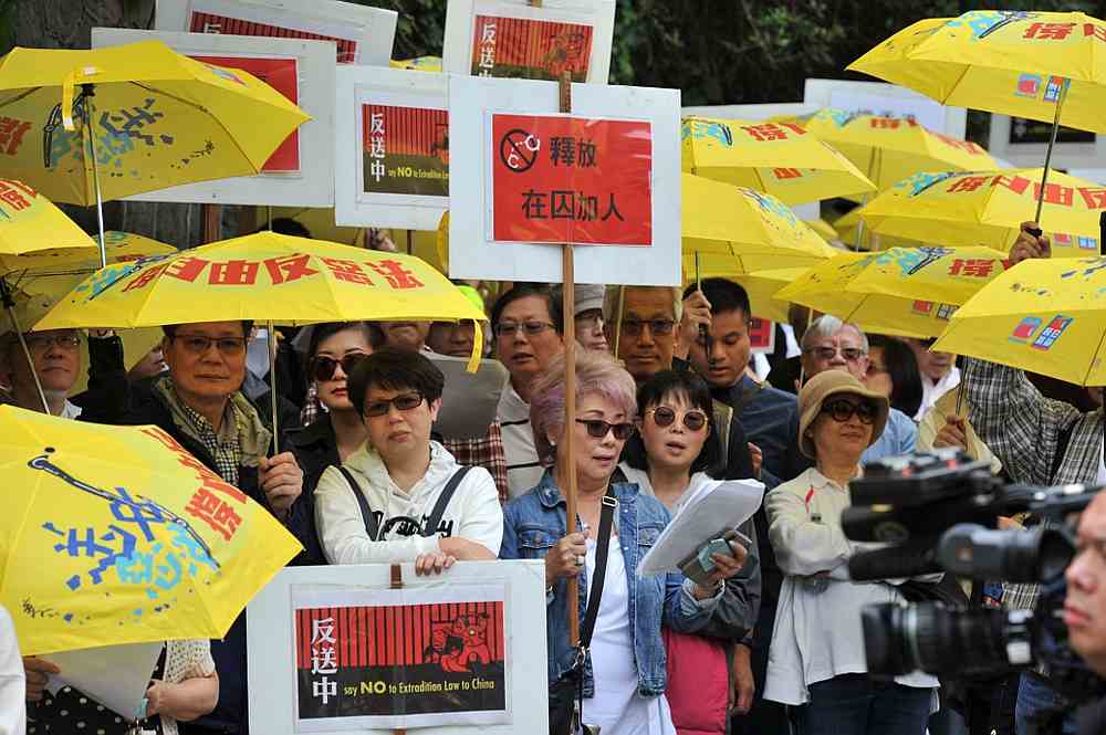 Demonstrators hold signs and yellow umbrellas as they gather in front of the Chinese Consulate in Vancouver, Canada to protest against a controversial extradition law for Hong Kong June 9, 2019. u00e2u20acu201d AFP pic