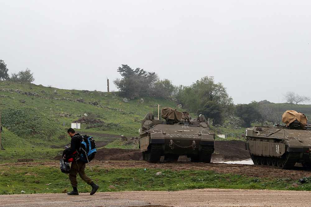 An Israeli soldier walks past armoured Israeli military vehicles in the Israeli-occupied Golan Heights March 25, 2019. u00e2u20acu201d Reuters pic