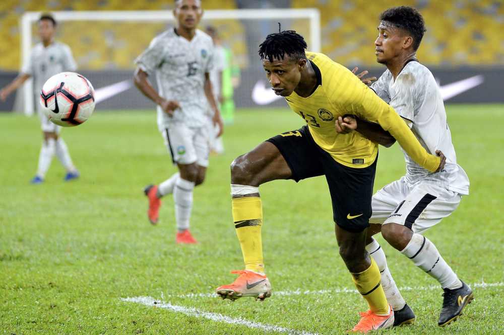 Pemain Harimau Malaya Mohamadou Sumareh (kiri) dihalang oleh oleh pemain Timor Leste Candido Monteiro De Oliveira (kanan) pada Perlawanan Kelayakan Piala Dunia 2022 dan Piala Asia 2023 di Stadium Nasional Bukit Jalil, 7 Jun 2019. u00e2u20acu2022 Foto Bernama