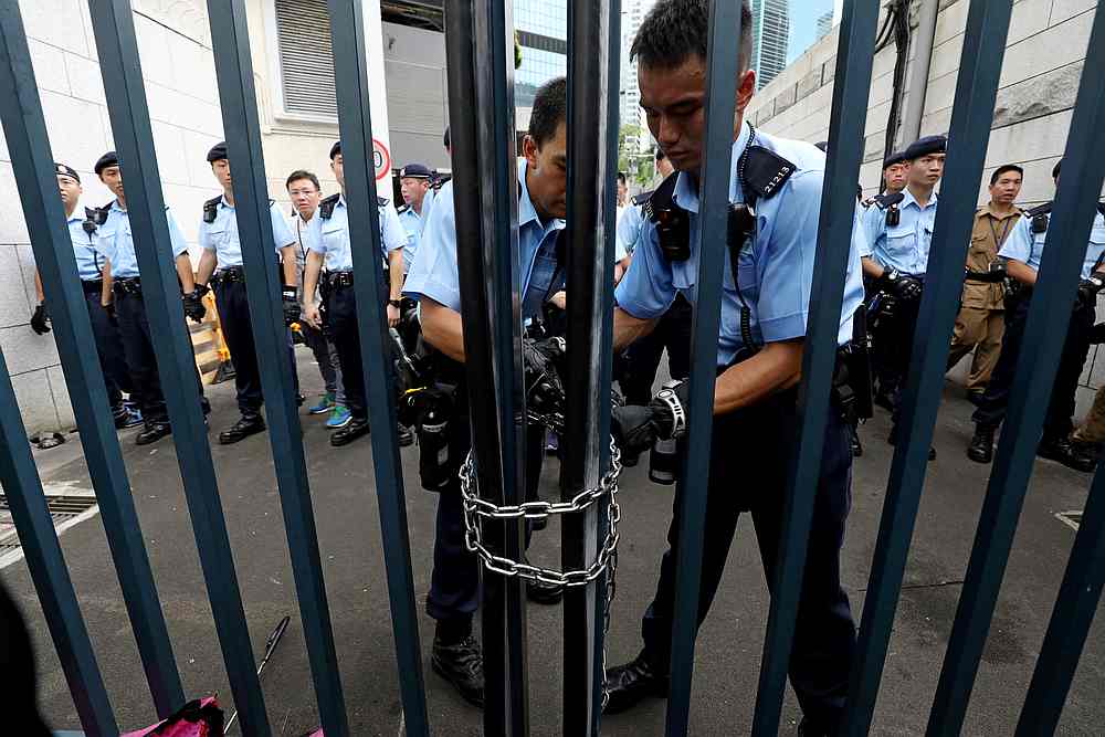Police officers lock the gate of a police headquarters after protesters attempt to storm in, in Hong Kong June 21, 2019. u00e2u20acu201d Reuters pic
